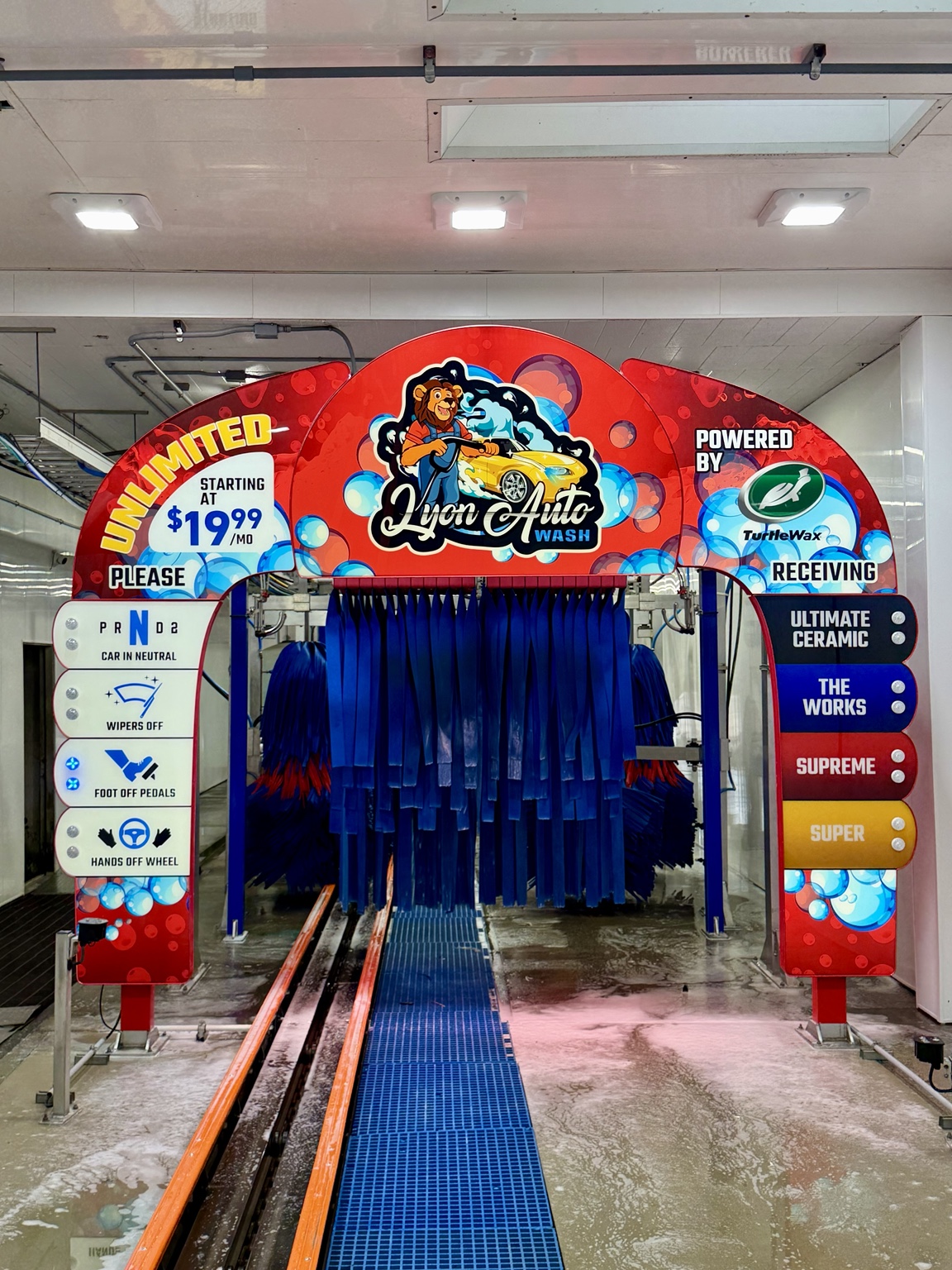 Lyon Auto Wash entrance arch with wash packages and vehicle instructions