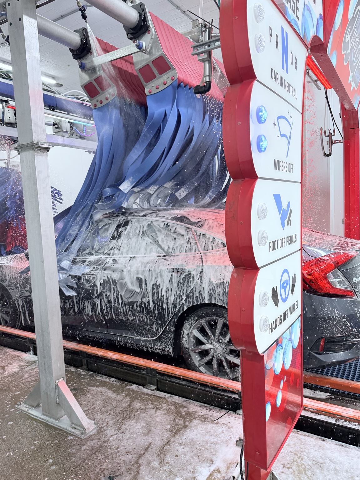 Vehicle covered in presoak and lava bath passing through the quad wave mitter